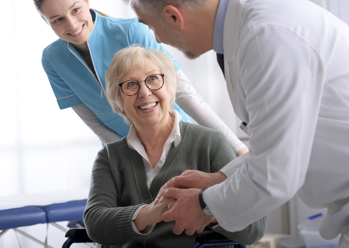 Doctor and smiling senior patient shaking hands in the office before visiting, healthcare and assistance concept