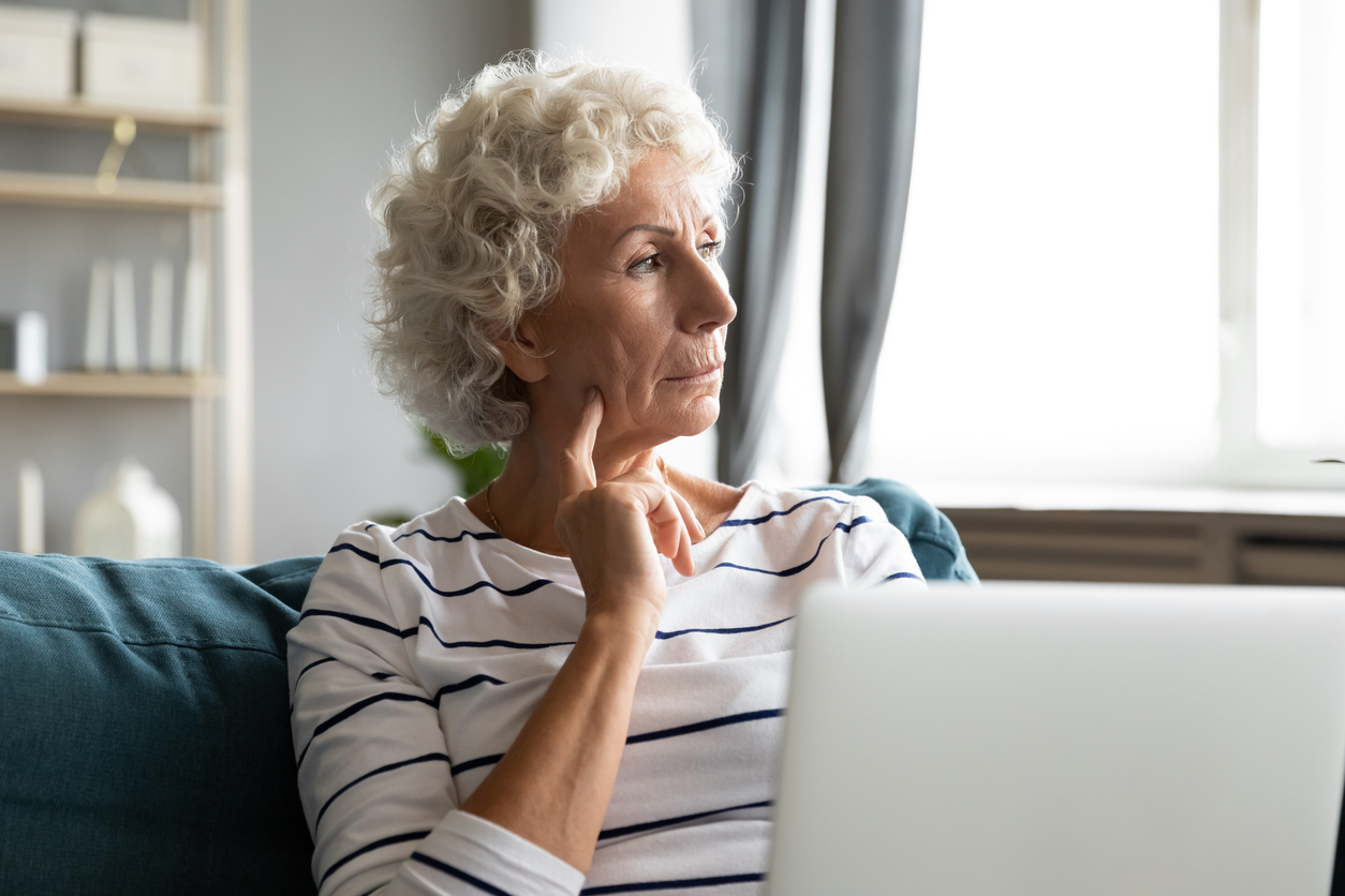 Older grandmother missing grown up children, using computer.